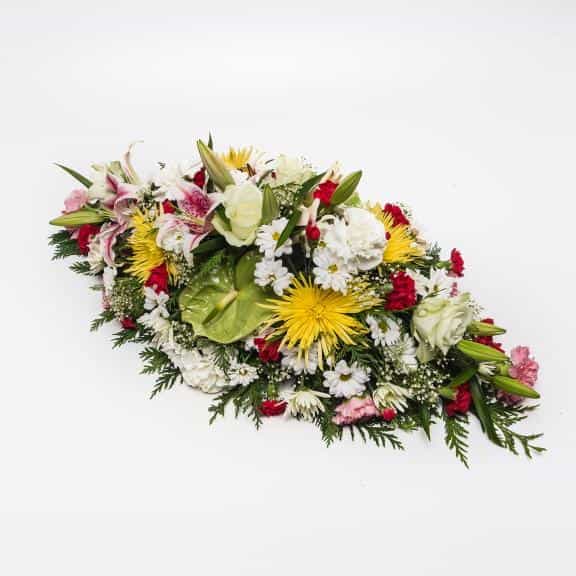<p>A beautiful large colourful Arrangement to celebrate ones life.</p><p>Created using a range of fresh flowers including Lilies, Roses, Chrysanthemums and Carnations. Measuring approximately 75cm long (2.5 feet) this arrangement is ideally suited for a funeral remembrance. </p><p>If particular flowers or colours are required simple request them during the checkout stage.</p>