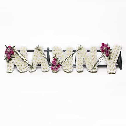 <p>A timeless piece ideal for a group of grand children to remember a loving Nanny.</p><p>Each letter is approximately 30cm high and 15cm wide. Created here in a mass of white double chrysanthemums and detailed with beautiful pink roses.</p><p>If desired this tribute can be created in different colours or styles, simply contact us to discuss.</p>